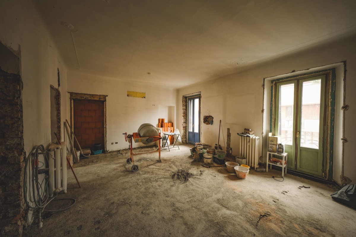 A room being renovated with a cement mixer and supplies
