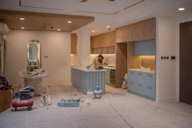 A kitchen remodel in progress with workers and tools