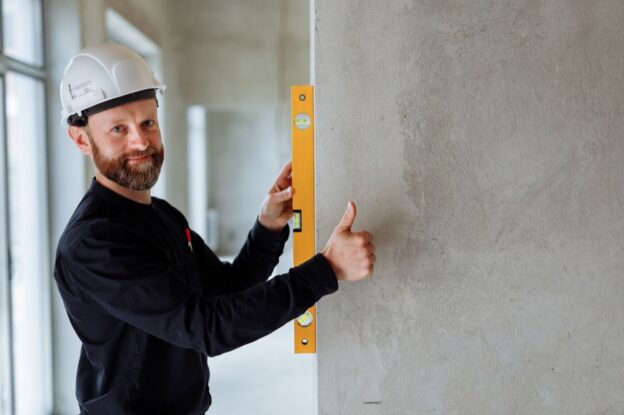 A contractor checking a wall during a renovation